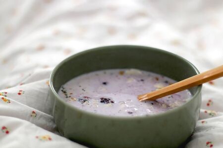 Bowl of oatmeal with berry fruit in bed. Selective focus.の写真素材