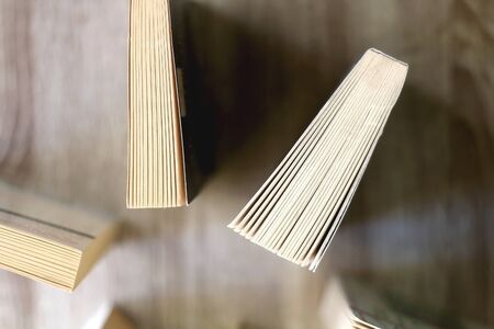 Paperback books on a wooden table. Top view.