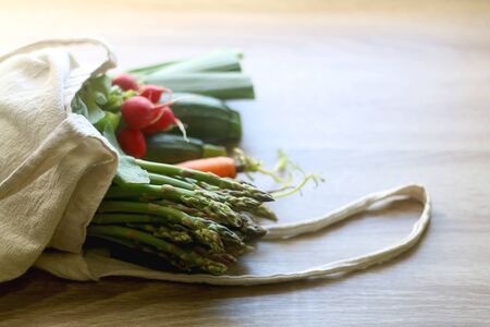 Canvas tote bag with various fresh vegetables. Selective focus.の写真素材