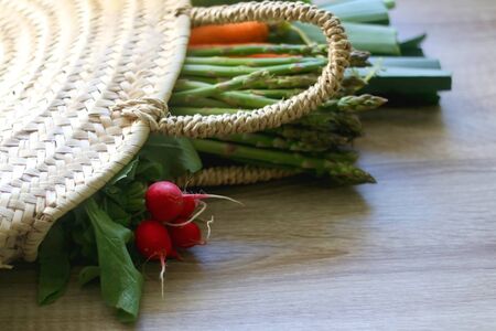 Wicker bag with leek, zucchini, carrot and asparagus. Selective focus.