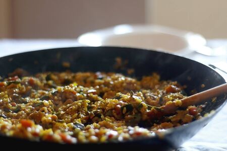 Wok with stir fry rice, vegetables and eggs, served on a table. Selective focus, back light.の写真素材