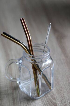 Reusable metal straws and cleaner in a glass jar. Selective focus.の写真素材