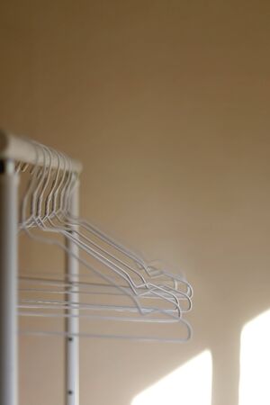 White empty hangers on a clothing rack. Selective focus.