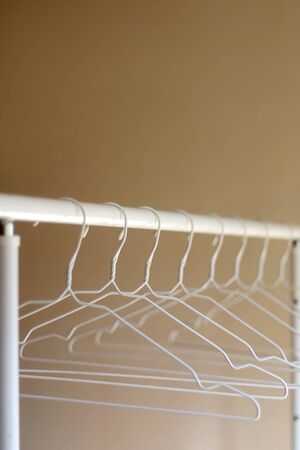 White empty hangers on a clothing rack. Selective focus.