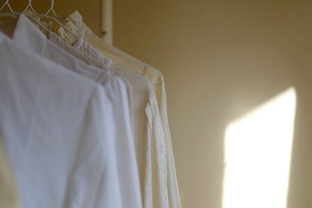 White vintage blouses on a clothing rack. Selective focus.の写真素材