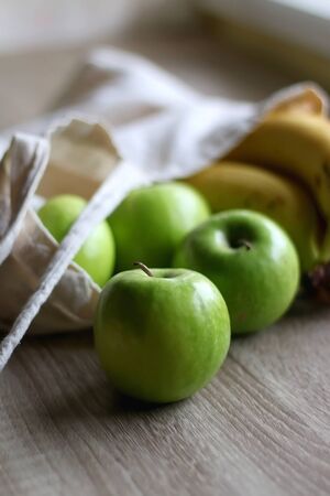 Canvas tote bag with apples and bananas. Selective focus.の写真素材