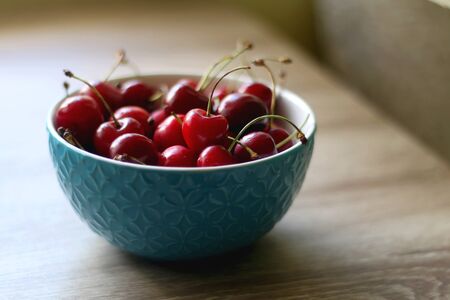 Bowl of cherries on a table indoor. Selective focus.