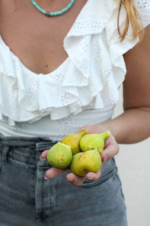 Unrecognizable person eating fresh picked figs. Selective focus.の写真素材