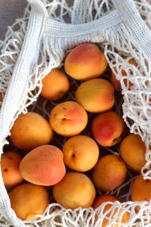 Reusable mesh bag filled with apricots. Top view.の写真素材