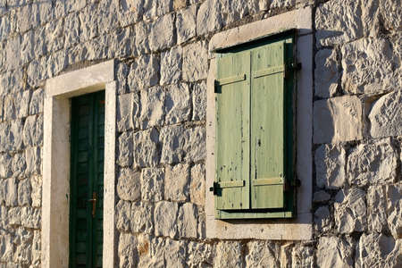 Traditional Mediterranean building in Split, Croatia with green wooden window shutters and stone facade. Selective focus.の写真素材