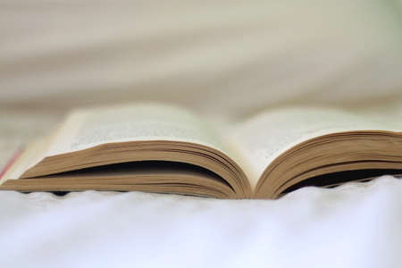 Open book on a bed. Selective focus.の写真素材