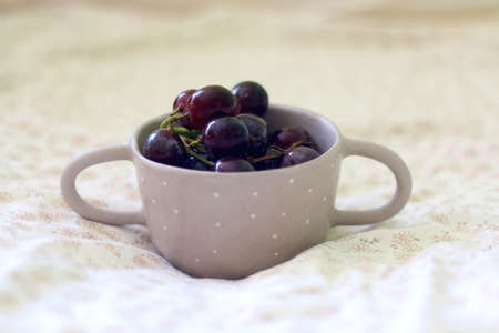 Bowl of grapes on a bed. Selective focus.