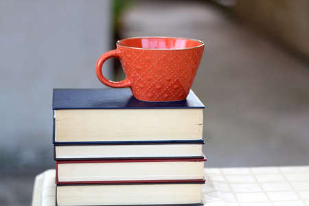 Stack of books and cup of tea or coffee. Selective focus.の写真素材