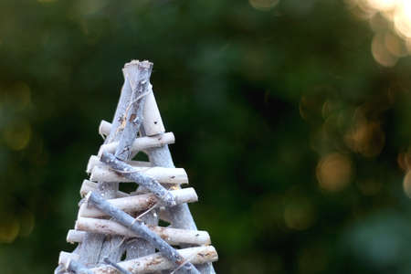 Small wooden Christmas tree, in silver and white tones. Selective focus, beautiful bokeh.