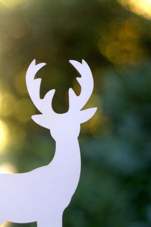 Wooden deer figurine, minimal Christmas decoration. Selective focus, beautiful bokeh.の写真素材