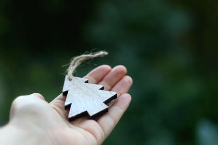 Hand holding wooden Christmas tree ornament. Selective focus.の写真素材