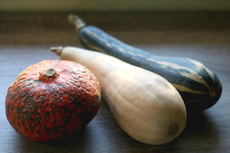 Three different gourds on wooden background. Selective focus.