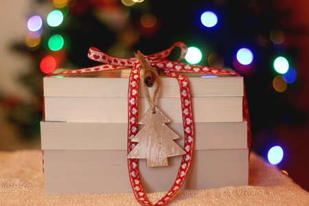 Stack of books under the Christmas tree. Selective focus.