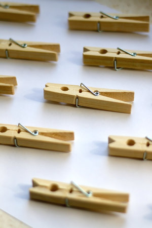 Wooden clothes pegs on white background. Selective focus.