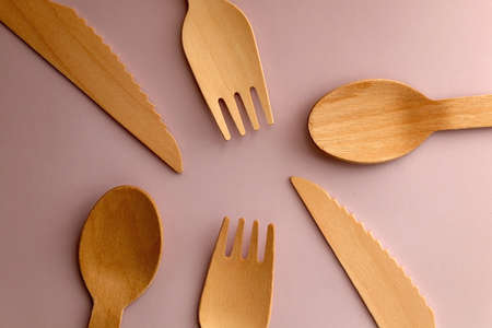 Wooden spoons, forks and knives on pastel pink background. Top view.の写真素材