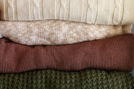 Stack of folded sweaters in neutral colors. Top view.の写真素材