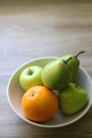 Bowl with pears, appples and oranges on a table. Selective focus.の写真素材