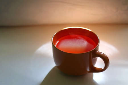 Cup of warm tea on a bed. Selective focus.