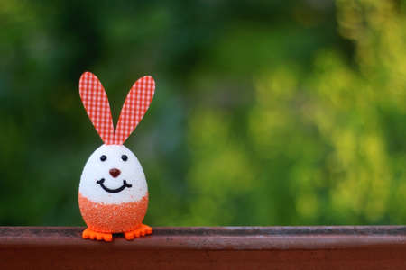 Easter egg with bunny ears. Easter decoration in a garden. Selective focus.の写真素材