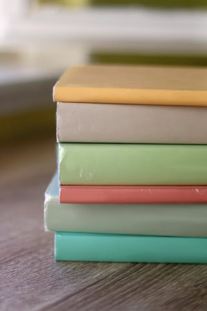 Stack of colorful books on a table. Selective focus.