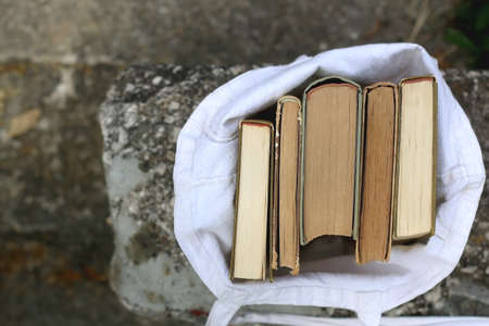 Linen tote bag filled with vintage books. Top view.の写真素材