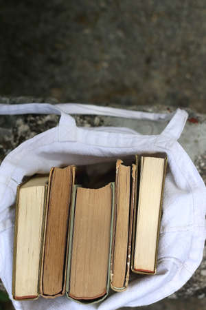 Linen tote bag filled with vintage books. Top view.の写真素材
