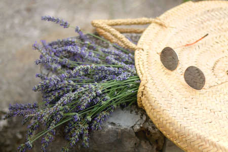 Straw bag filled with fresh lavender flowers and retro sunglasses. Selective focus.の写真素材