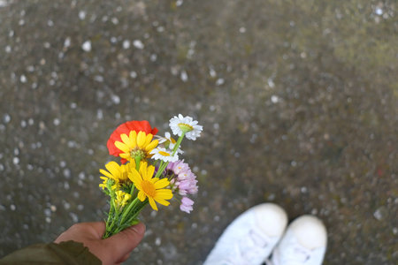 Unrecognizable person holding a bouquet of colorful wild flowers. Top view.の写真素材