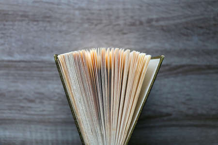 Vintage hardcover book on a wooden table. Top view.