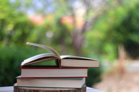 Stack of hardcover books in a garden. Selective focus.の写真素材
