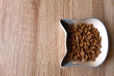 Cat shaped bowl filled with dry cat food. Top view.の写真素材