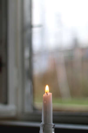 Lit candlestick in a glass candle holder. Selective focus.の写真素材