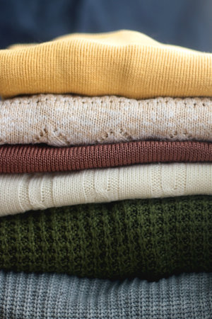 Pile of colorful sweaters in warm tones. Selective focus.の写真素材