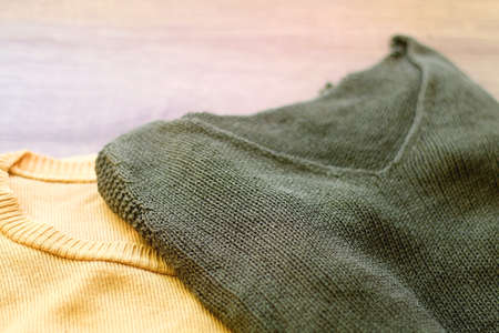 Green and yellow sweater on wooden background. Selective foucs.の写真素材