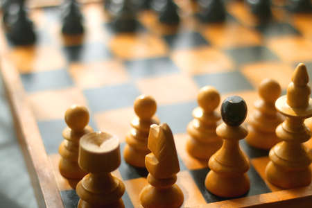 Wooden chessboard and vintage carved figurines. Selective focus.