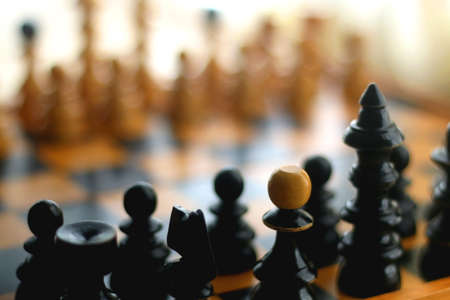 Wooden chessboard and vintage carved figurines. Selective focus.