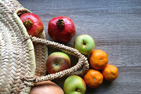 Straw tote bag filled with butternut squash and various fruit. Flat lay.の写真素材