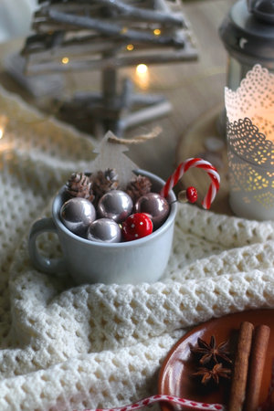 Stack of chocolate chip cookies tied with ribbon, cinnamon, anise, various Christmas decorations and lit candles. Hygge at home. Selective focus.の写真素材