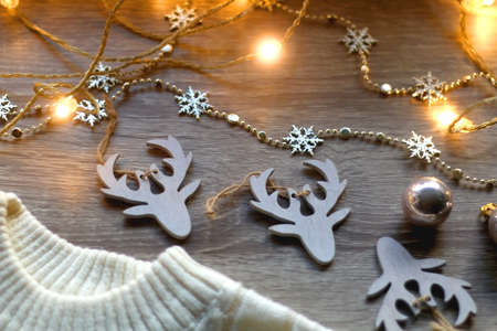 White cable knit sweater and various Christmas decorations on wooden background. Selective focus.の写真素材