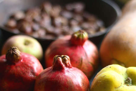 Pan with chestnuts, butternut squash and various fruit on dark background. Selective focus.の写真素材