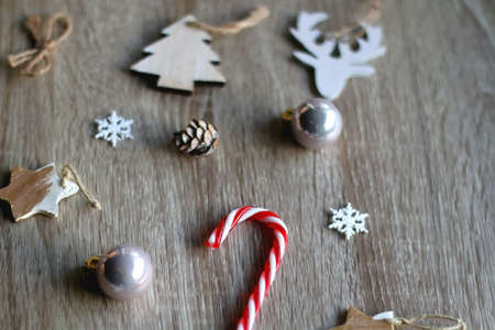 Various Christmas ornaments and candy cane on wooden background. Selective focus.