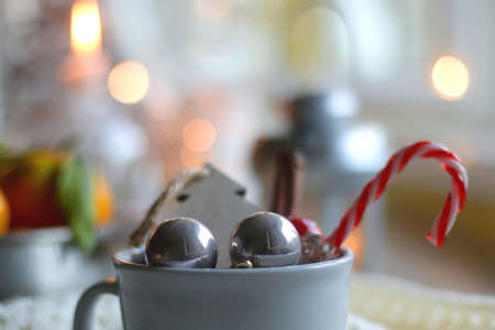 Silver bowl filled with fresh tangerines, various Christmas decorations, lit candles and soft...
