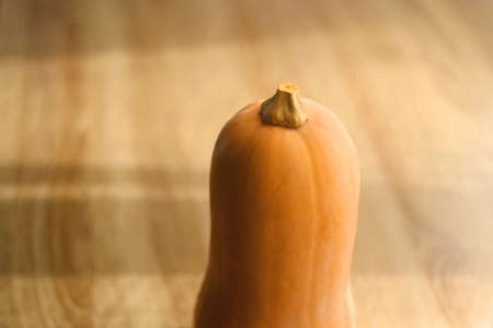 Butternut squash on the table, illuminated by sunlight. Selective focus.