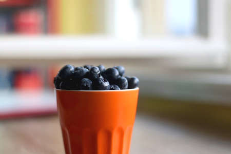 Cup of fresh blueberries on wooden table. Selective focus.の写真素材