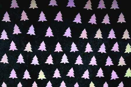 Pastel colored Christmas confetti on dark background. Flat lay.